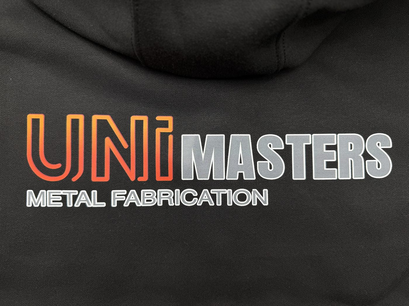 Company logo across hoodie back — metal fabrication workwear