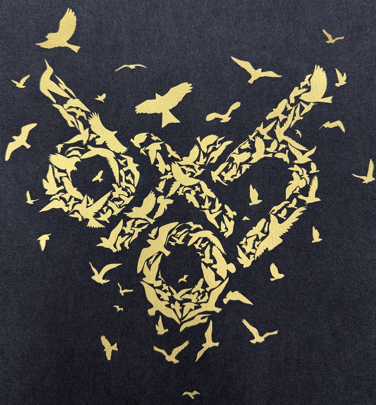 Metallic gold bird-flock artwork on black tee
