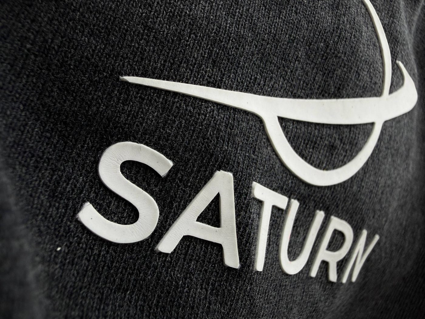 Raised white puff logo on dark heather crew